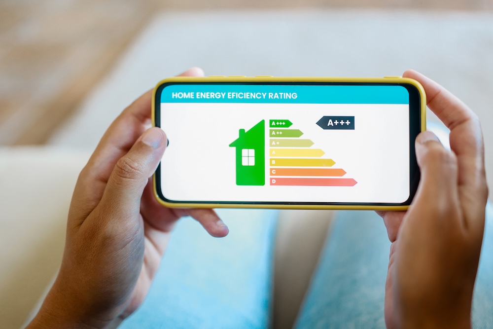 person holding home energy performance stats on a mobile phone app