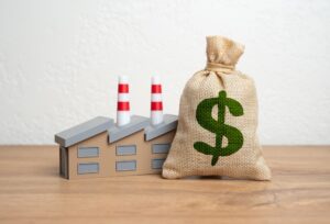 money bag sitting next to an industrial plant model