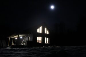full moon shining above a house at night
