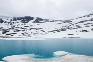 glacial lake with snow and ice and blue water