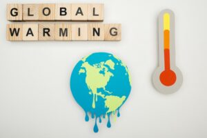 Wooden letters spelling out global warming with an earth and thermometer