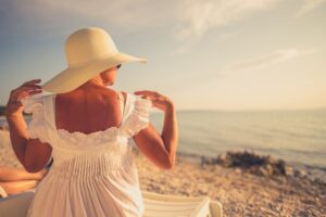 mature woman sitting in the sun at the beach