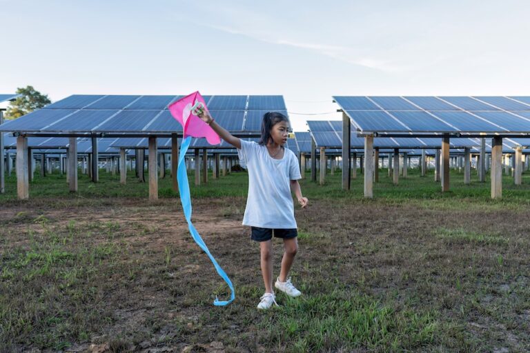 Solar panel on a solar farm with a young girl playing