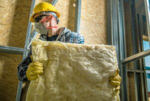 worker holding a piece of wool insulation