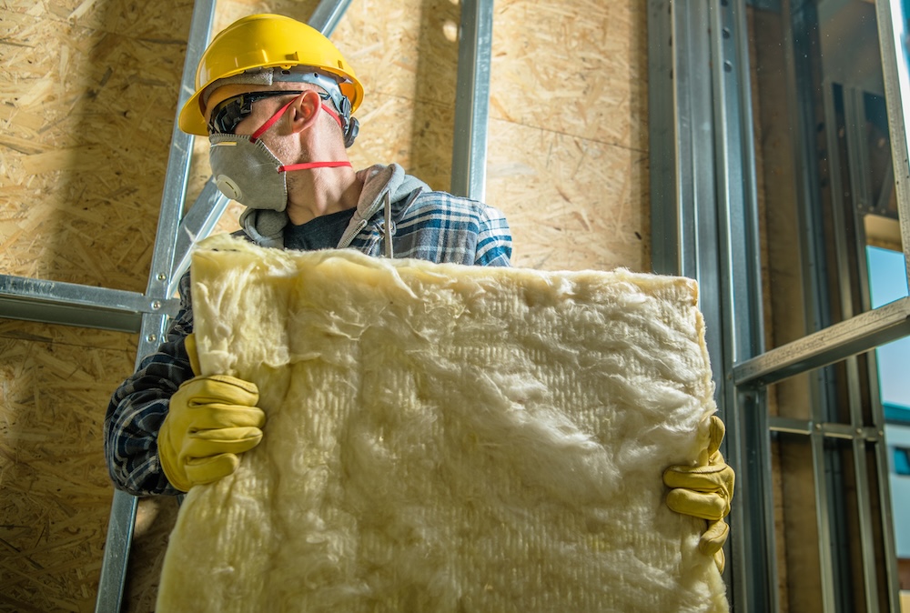 worker holding a piece of wool insulation