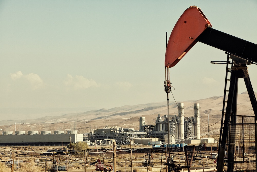 Oil pump in front of an oil refinery
