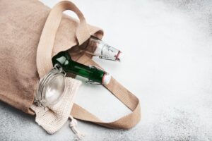 Reusable burlap bag with glass bottles and jars