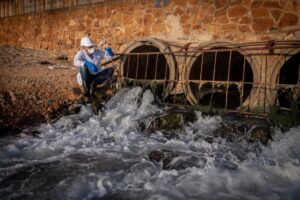 Scientist in protective gear testing water
