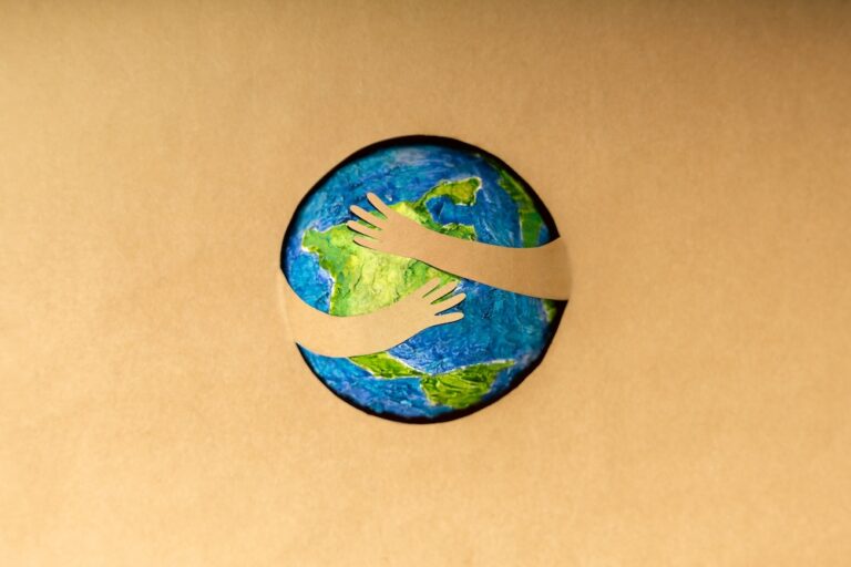 Earth with paper hands hugging it