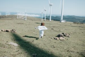 Girl running to wind turbines