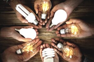 Hands holding different lightbulbs safely