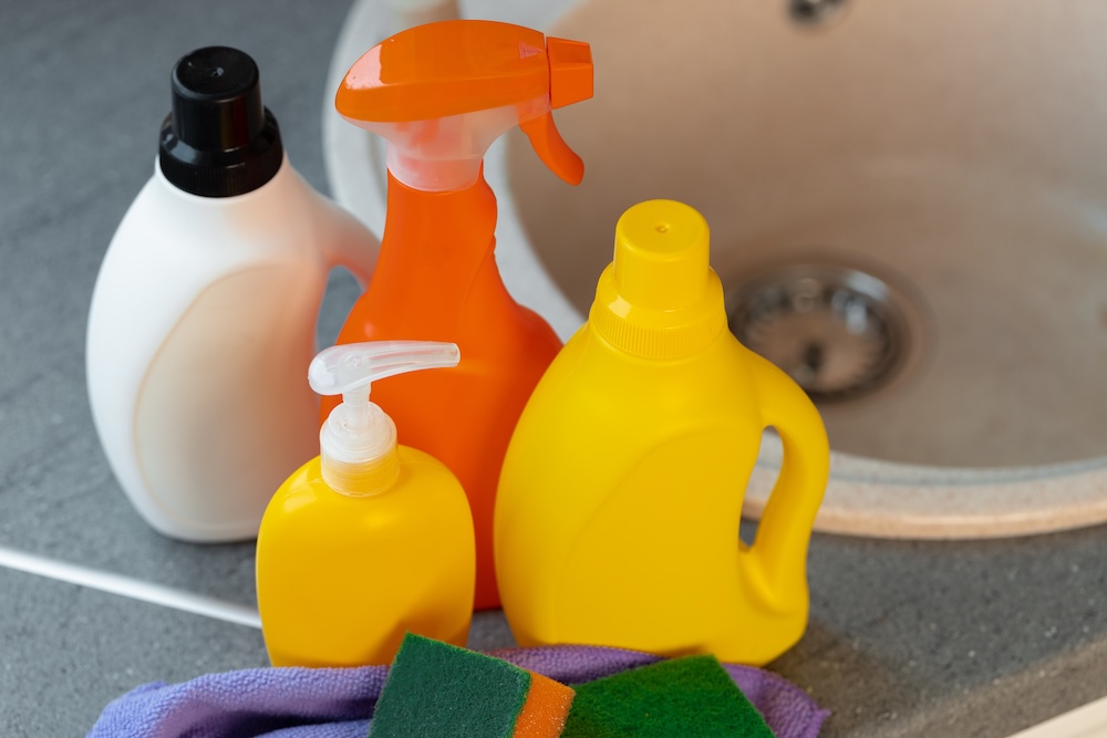 Household cleaning agents in bottles near a sink