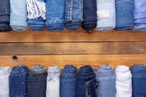 Different blue jeans on a wooden table