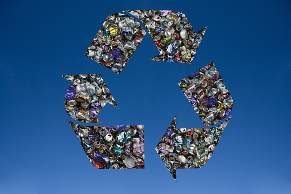 Recycled tin cans in shape of recycling symbol