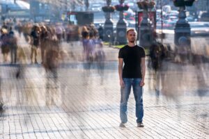 Man standing in the middle of fast paced blurred crowd