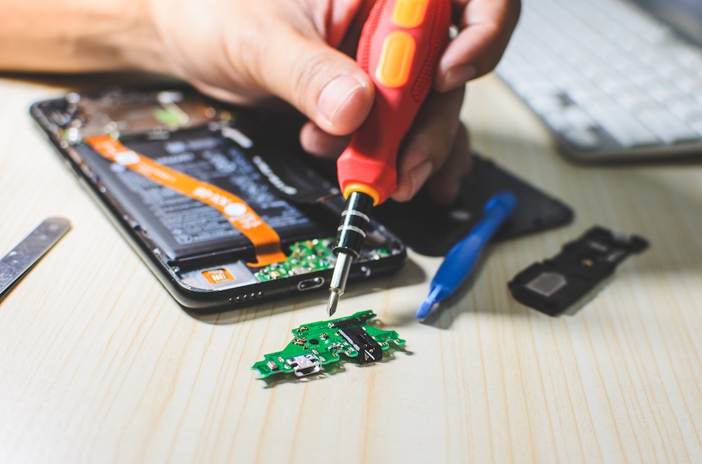 person using tools to repair a smartphone